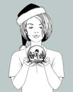 Girl in Santa hat holding a snow globe with a snowman in her hands Royalty Free Stock Photo