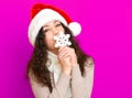 Girl in santa hat portrait with big snowflake toy posing on pink color background, christmas holiday concept, happy and emotions Royalty Free Stock Photo