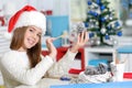 Girl in Santa hat preparing for Christmas paintig pine cone