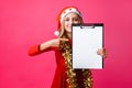 Teen girl in Santa hat and tinsel on neck, holding tablet with c Royalty Free Stock Photo
