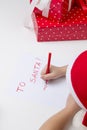 Girl in santa hat, writes a letter to Santa