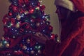 Girl in Santa hats placing a ornament on a Christmas tree