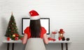 Girl with Santa`s hat work on computer at Christmas time Royalty Free Stock Photo