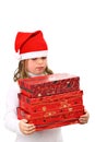 Girl in Santa's red hat carrying three presents Royalty Free Stock Photo