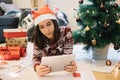 Girl with Santas hat looking tablet while lying Royalty Free Stock Photo