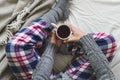 Girl sat on bed in cozy pyjamas drinking a cup of tea Royalty Free Stock Photo