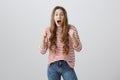 Girl is scared of friend who jumped from bushes. Pretty european teenager standing with raised clenched fists, gasping