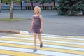 A girl of school age crosses the road on a pedestrian crossing Royalty Free Stock Photo