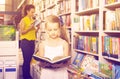 Girl in school age looking in open chosen book