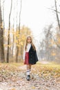 A girl in a school red plaid skirt walks through the autumn forest after school Royalty Free Stock Photo