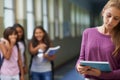 Girl, school and sad student bullying victim feeling depression, lost or stressed in hallway or corridor. Kids laughing Royalty Free Stock Photo