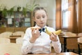 Girl in school uniform chooses food for lunch Royalty Free Stock Photo