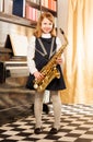 Girl in school uniform dress holds alto saxophone Royalty Free Stock Photo