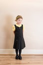 Girl (4) in school uniform pinafore