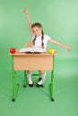Girl in a school uniform sitting at a desk and stretches
