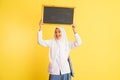 girl in school uniform in veil carrying black chalkboard up