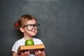 Girl schoolgirl with books and apple in a school board Royalty Free Stock Photo