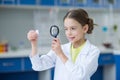 Girl scientist looking at glass microscope slide through magnifier Royalty Free Stock Photo
