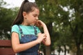 Girl scratching arm with insect bite in park Royalty Free Stock Photo