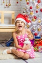 Girl screams happily holding candle in her hands and sitting by Christmas trees Royalty Free Stock Photo