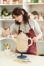 Girl sculptor in the workshop sculpts from clay