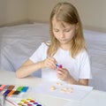 A girl sculpts from clay in a white sunny room. Home art teaching concept. Creative child at work. Creative children`s modeling