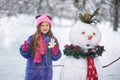 Girl sculpts a snowman in the Park. Royalty Free Stock Photo