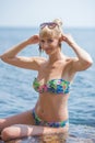 Girl in swimsuit playing with the seaweed in shallow water