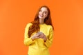 Girl searching gifts for holidays online. Carefree happy redhead female student using smartphone app, laughing joyfully Royalty Free Stock Photo