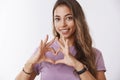 Girl searching key your heart. Attractive feminine tender tanned european woman curly hair, showing love gesture smiling Royalty Free Stock Photo