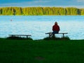 Girl seating on the bench on river bank background