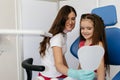 Girl seating in dental office and looking at her teeth the mirror Royalty Free Stock Photo