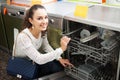 Girl selecting modern dishwasher Royalty Free Stock Photo