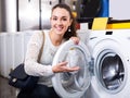 Girl selecting new washing machine . Royalty Free Stock Photo