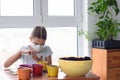 Girl in self-isolation at home planting seeds in pots