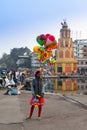 A girl selling colorful balloon arts near bank of Godavari river, Nashik City, Maharashtra, India, crowded by local people,