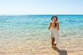 Girl sends an air kiss to the camera. a beautiful carefree Woman relaxing at the beach enjoying her sun white dress. girl sends an Royalty Free Stock Photo