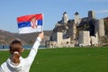 A girl with a Serbian flag looks at the Golubac fortress