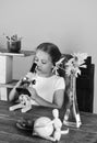 Girl with serious face looks into microscope. Back to school and beauty concept. Kid and lab supplies