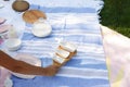 Girl with a set of white empty sauceboats on a wooden tray serves a picnic