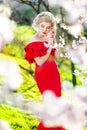 Girl or woman holding white, blossoming flowers in mouth and hair with naked shoulders in spring garden on sunny Royalty Free Stock Photo