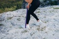 The girl shakes her legs with purple elastic rubber. Sport in nature