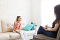 Girl Sharing Problems With Psychologist Sitting On Sofa