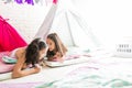 Girl Sharing Secrets With Friend While Lying In Tipi Tent