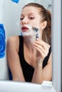 Girl shaving in bathroom Royalty Free Stock Photo