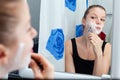 Girl shaving in bathroom Royalty Free Stock Photo