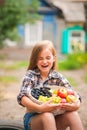 Girl in shirt and shorts with a basket of fruit. Girl farmer with apples and grapes. Concept of ecological food, person Royalty Free Stock Photo