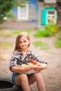 Girl in shirt and shorts with a basket of fruit. Girl farmer with apples and grapes. Concept of ecological food, person Royalty Free Stock Photo