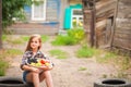 Girl in shirt and shorts with a basket of fruit. Girl farmer with apples and grapes. Concept of ecological food, person Royalty Free Stock Photo