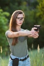 Girl shooting instructor with a gun in his hand aiming at the target